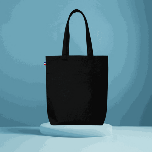 Sac cabas en coton beige avec soufflet de fond, fabriqué en France, posé sur une table en bois avec accessoires de mode

